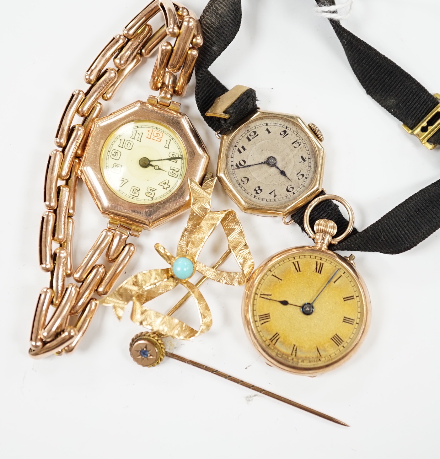 Two early 20th century 9ct gold manual wind wrist watches, one on an expanding 9ct bracelet, a 9ct gold fob watch, a 750 and turquoise set 'butterfly' shaped ribbon bow brooch and a stick pin.